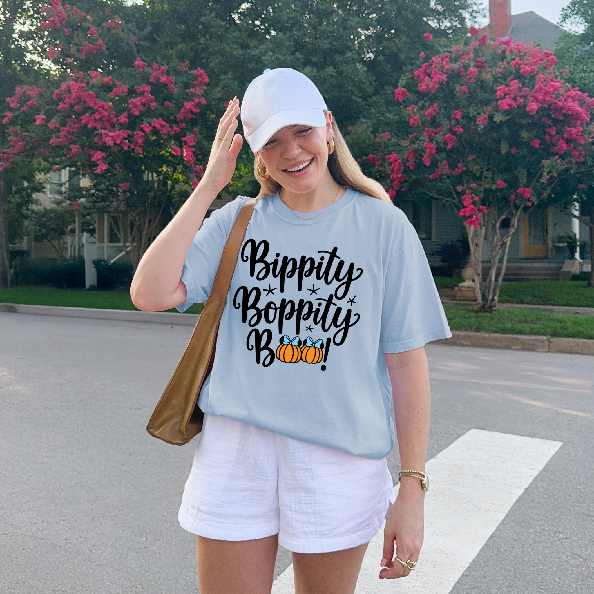Person wearing a light blue t-shirt with 'Bippity Boppity Boo' text and pumpkin graphics, standing outdoors.