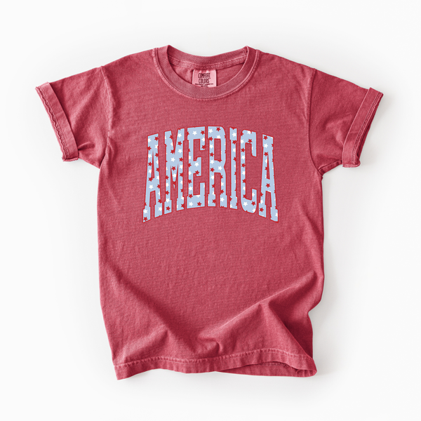 Red t-shirt with 'AMERICA' printed on it against a white background