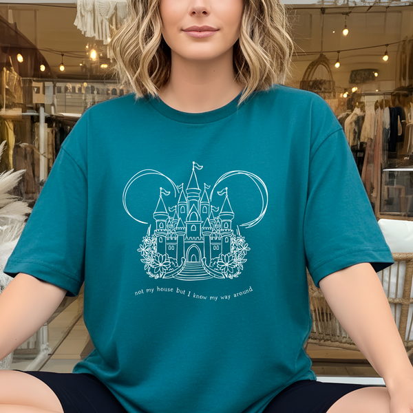 Person wearing a teal t-shirt with a castle design in a store setting