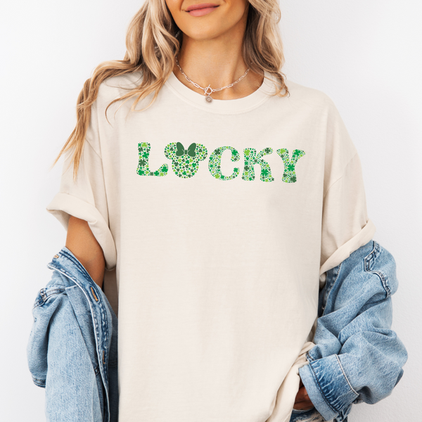 Person wearing a beige sweatshirt with 'Lucky' printed in green hearts on a white background